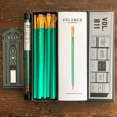 two pencils, one green and the other yellow in a box on a wooden table