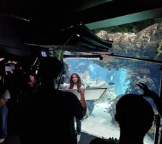 people standing in front of an aquarium looking at the fish