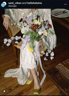 a woman sitting on a chair holding a bouquet of flowers in her hand and wearing yellow shoes