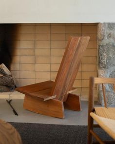 a wooden chair sitting in front of a fire place