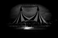 a circus tent is lit up at night