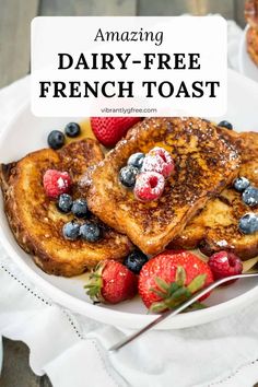 french toast with fresh berries and powdered sugar on top in a white bowl next to strawberries