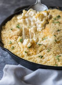 a spoonful of macaroni and cheese is being lifted from a skillet