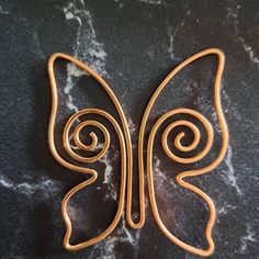 an image of a butterfly broochle on a marble surface with swirls in the center