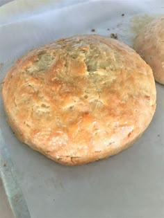 two round breads sitting on top of a piece of wax paper