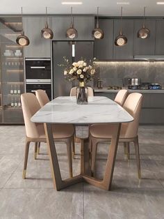 a dining room table surrounded by chairs and vase with flowers on it in front of an oven