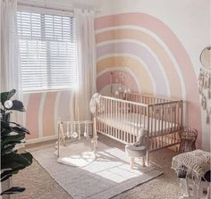 a baby's room with pink and white stripes on the wall