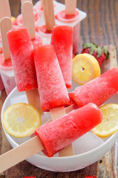 watermelon popsicles with lemons and strawberries on the side in a bowl