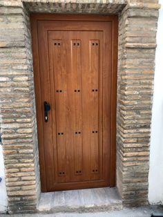 a wooden door is shown in front of a brick wall