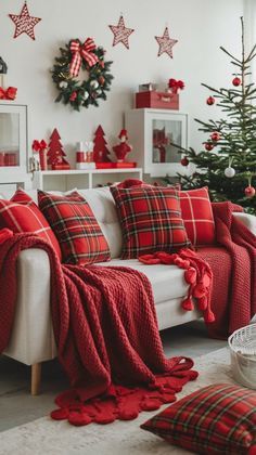 a living room decorated for christmas with red and green plaid blankets on the couches