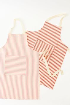 two red and white striped aprons sitting next to each other