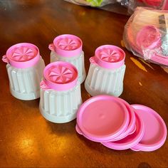 pink and white plastic plates and cups on a wooden table