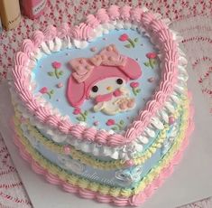 there is a heart shaped cake with a hello kitty decoration on the top and sides