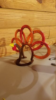 a wooden turkey figurine sitting on top of a table next to some scissors