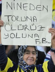 a woman holding up a sign in front of her head with words written on it