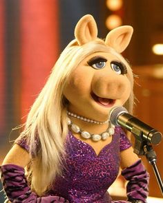 miss piggy singing into a microphone on stage