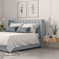 a bed with white sheets and blue headboard next to a plant in a room