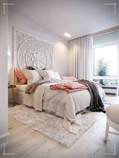 a bedroom with white walls and wood flooring has a large bed in the center