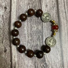 Crafted using green cypress wood, gemstones, stretch cord, and a delicate Miraculous Medal, this Catholic bracelet measures 7 inches in length. Black natural wood Catholic Bracelet with red gemstone beads, Catholic Gift, Holy Bracelet,Praying Bracelet,Wood Bracelet, Nativity Bracelet ➡️ NOTE: - Please note that the final product may vary slightly in color or wood grain compared to what is depicted in the photos. This can be due to factors such as the unique characteristics of the wood, the quali Brown Rosary Bracelet With 8mm Beads For Meditation, Spiritual Brown Rosary Bracelet With Wooden Beads, Spiritual Brown Rosary Bracelet For Meditation, Spiritual Brown Rosary Bracelet With Beads, Spiritual Wooden Beaded Bracelets, Spiritual Brown Bracelets With Wooden Beads, Spiritual Rosary Bracelet With Wooden Beads, Spiritual Stretch Bracelet With Wooden Beads For Meditation, Spiritual Wooden Beads Stretch Bracelet For Healing