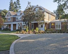 a large brick house surrounded by trees and grass