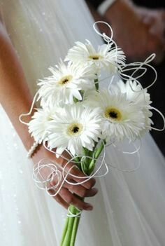 a bride holding a bouquet of white daisies in her wedding dress and the caption says, i love you