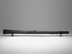 a long piece of wood sitting on top of a white floor next to a wall