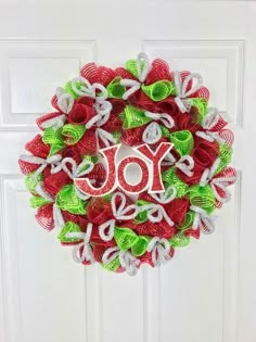 a red and green wreath with the word joy on it