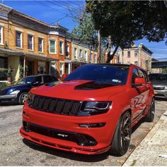 the red jeep is parked on the side of the street