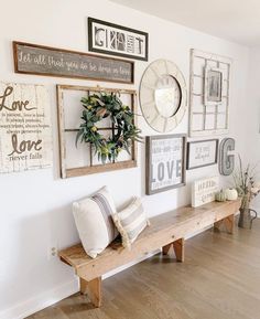 a wooden bench sitting next to a wall covered in pictures and framed art on it