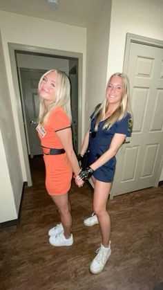 two women dressed in orange and blue standing next to each other