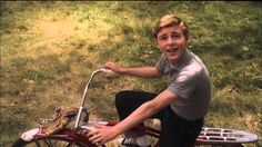 a young boy is sitting on a small bike