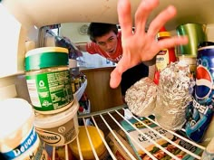 a person reaching for food in an open refrigerator