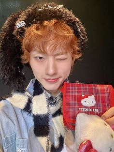 a boy with red hair holding a stuffed animal