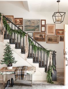 a staircase decorated for christmas with garland and lights