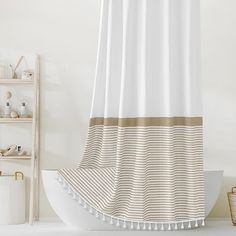 a white and brown shower curtain in a bathroom next to a shelf with toiletries