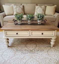 a coffee table with two planters on it in the middle of a living room