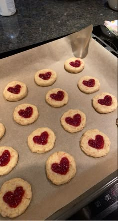 heart shaped cookies sitting on top of a cookie sheet