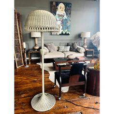 a living room filled with furniture and a large lamp on top of a hard wood floor