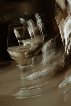 blurry photograph of wine glasses sitting next to each other