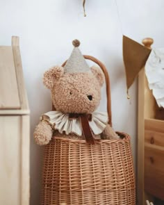 a teddy bear sitting in a wicker basket