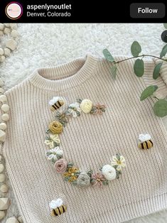 a sweater with flowers and bees on it