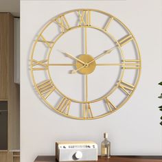 a large clock on the wall with roman numerals and an analog radio next to it