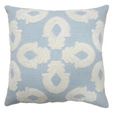 a light blue and white pillow with an intricate design on it's back side