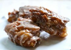 two pieces of chocolate covered doughnuts on a white plate