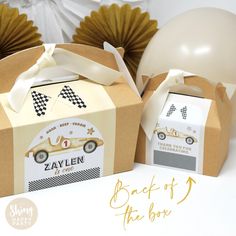 two boxes that are sitting next to each other with balloons in the background and some decorations around them