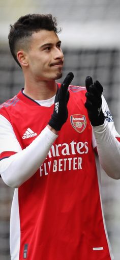 a soccer player is holding his hand up in the air and making a gesture with both hands