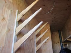 the inside of a storage room with wooden shelves and plywood boards on the walls