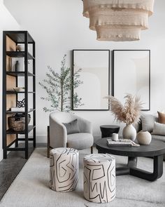 a living room filled with furniture next to a book shelf and two vases on top of tables