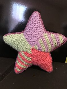 a crocheted star pillow sitting on top of a table