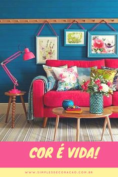 a living room with blue walls and red couches, colorful pillows and pictures on the wall